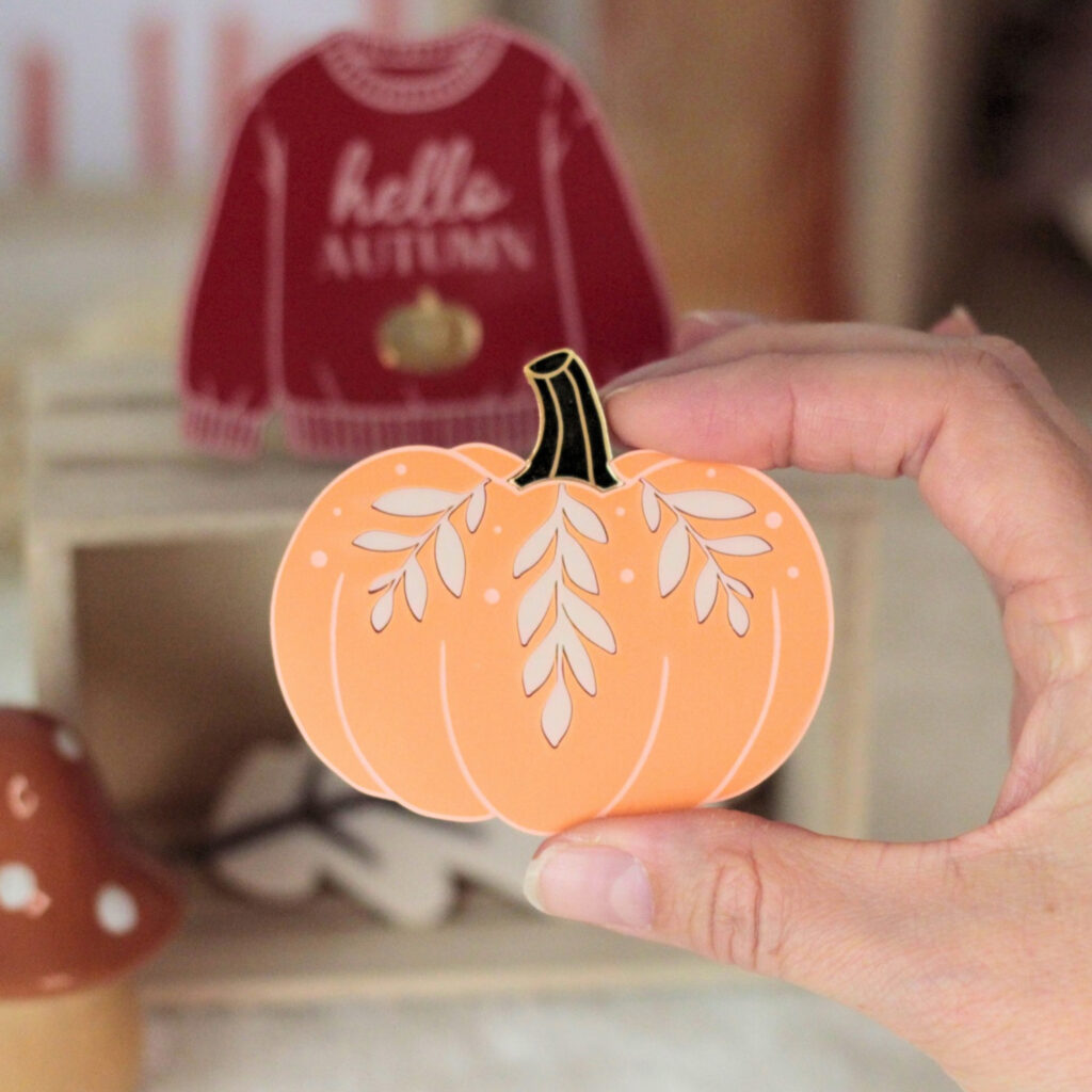 Magnet citrouille orange tenu à la main avec feuillages peints à la main et détail miroir doré