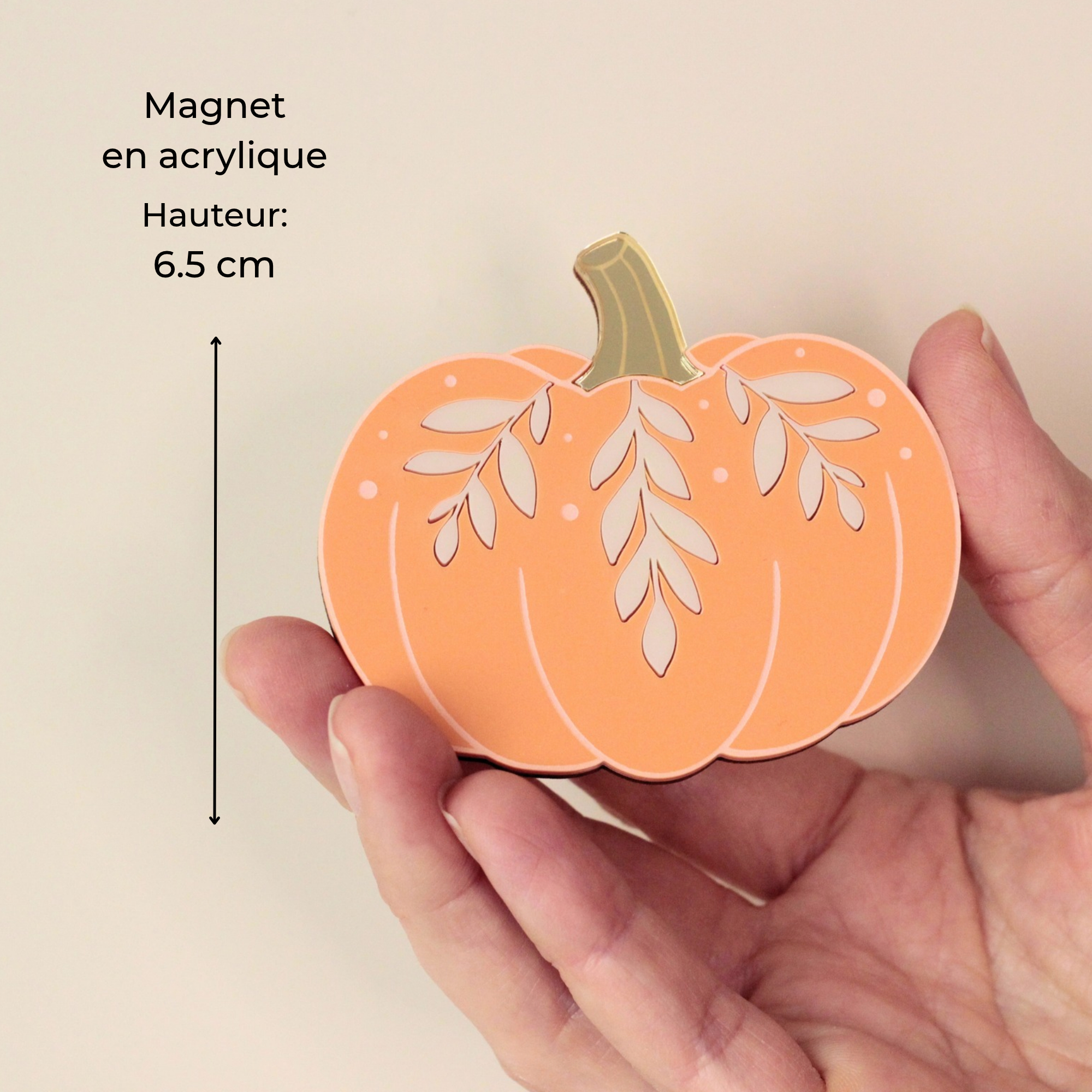 Magnet citrouille orange en acrylique de 6,5 cm tenu dans la main, avec feuillages peints à la main