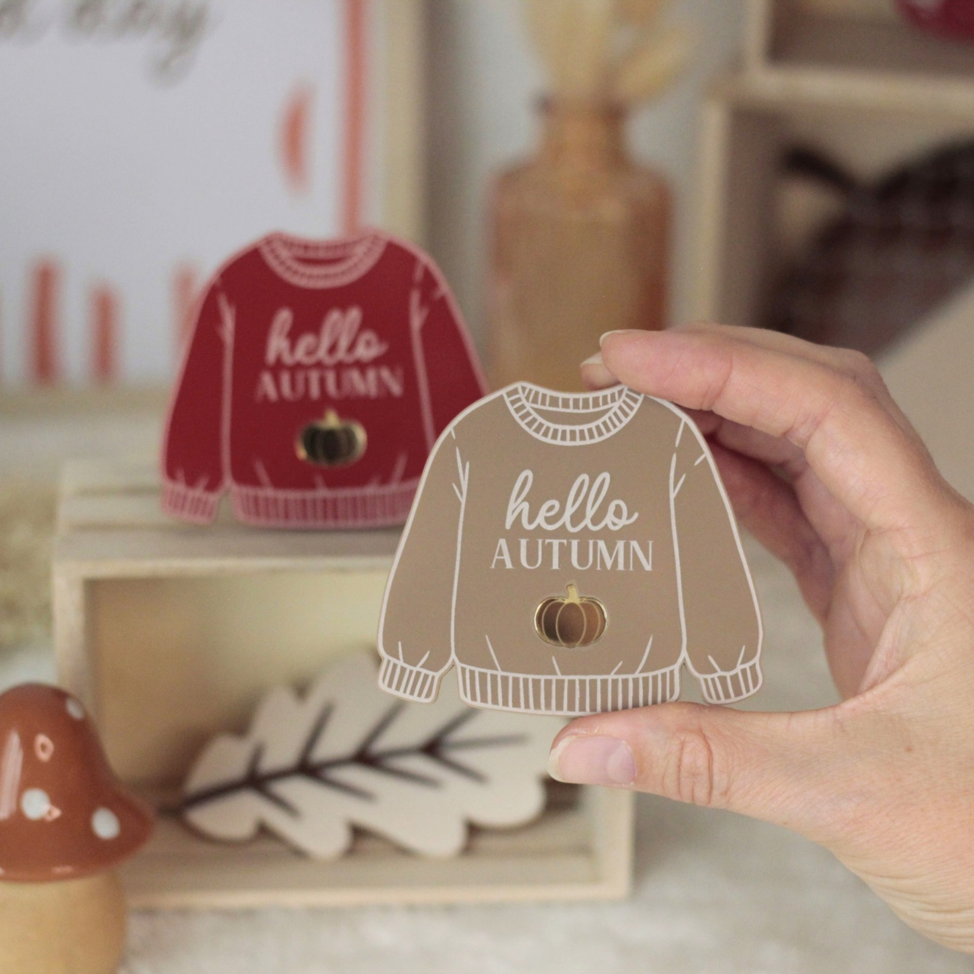 Magnet pull Hello Autumn moka tenu à la main dans une ambiance cosy