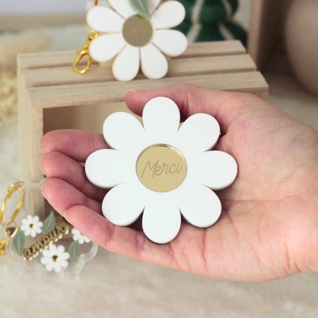 Miroir marguerite personnalisable tenu à la main avec petit mot gravé