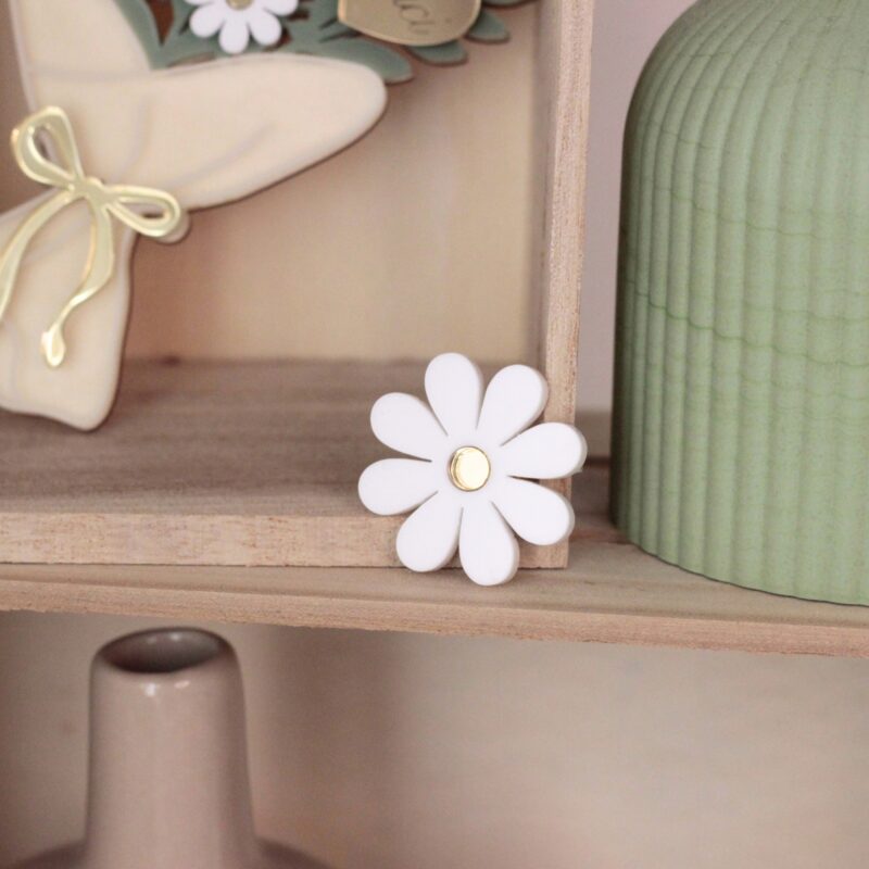 Pin’s marguerite présenté dans une décoration fleurie